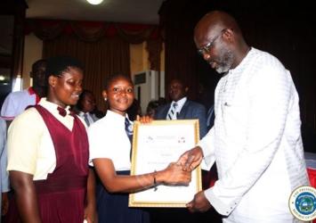 Students presenting a certificate of honor in appreciation of the President's policy to underwrite their WASSCE feesExecutive Mansion Photo
